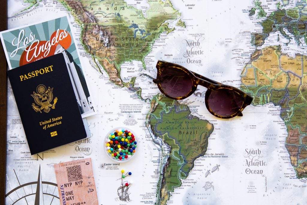 a passport and sunglasses on top of a map