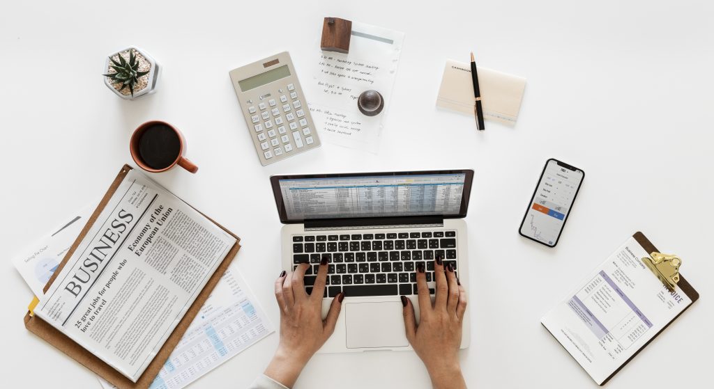 woman using laptop, journal, calculator and celphone