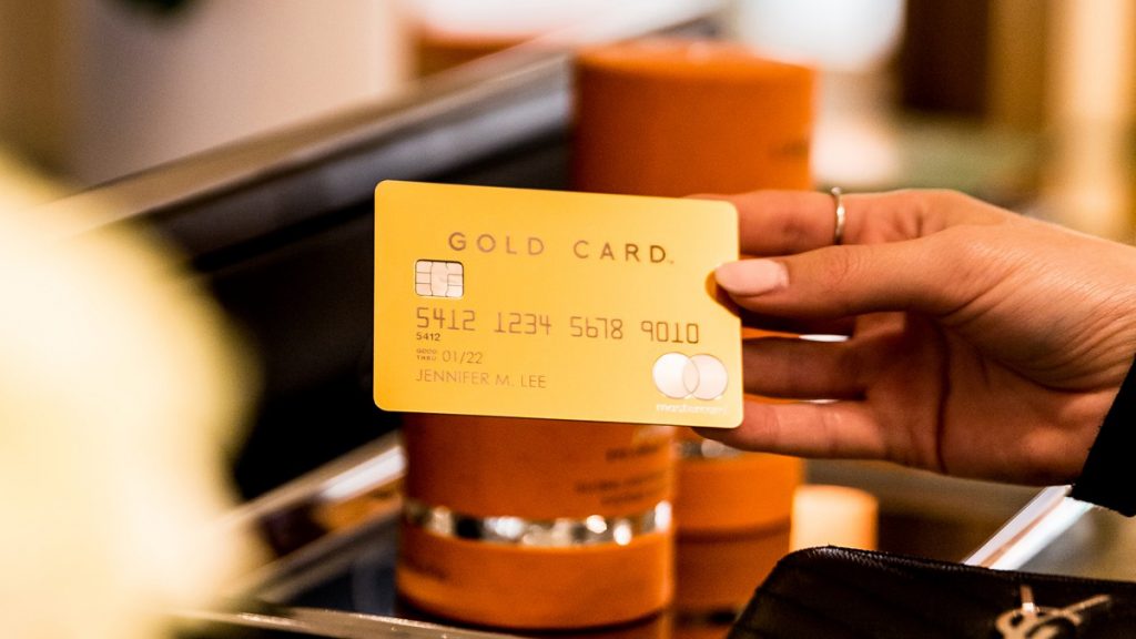 woman holding a luxury gold card