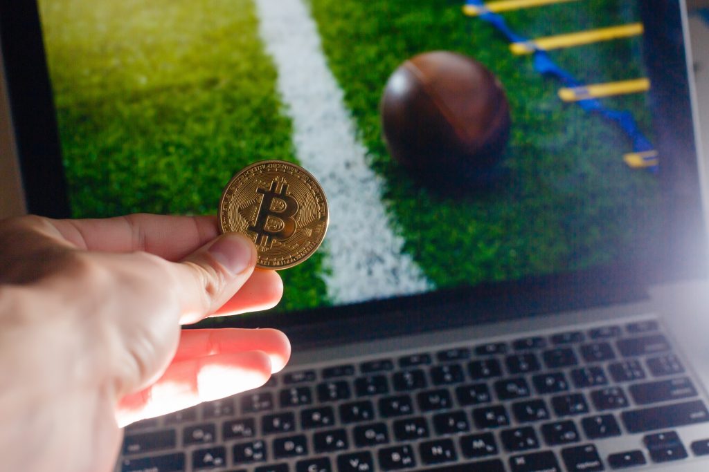 Golden bitcoin coin against digital currency sport, ball backgro
