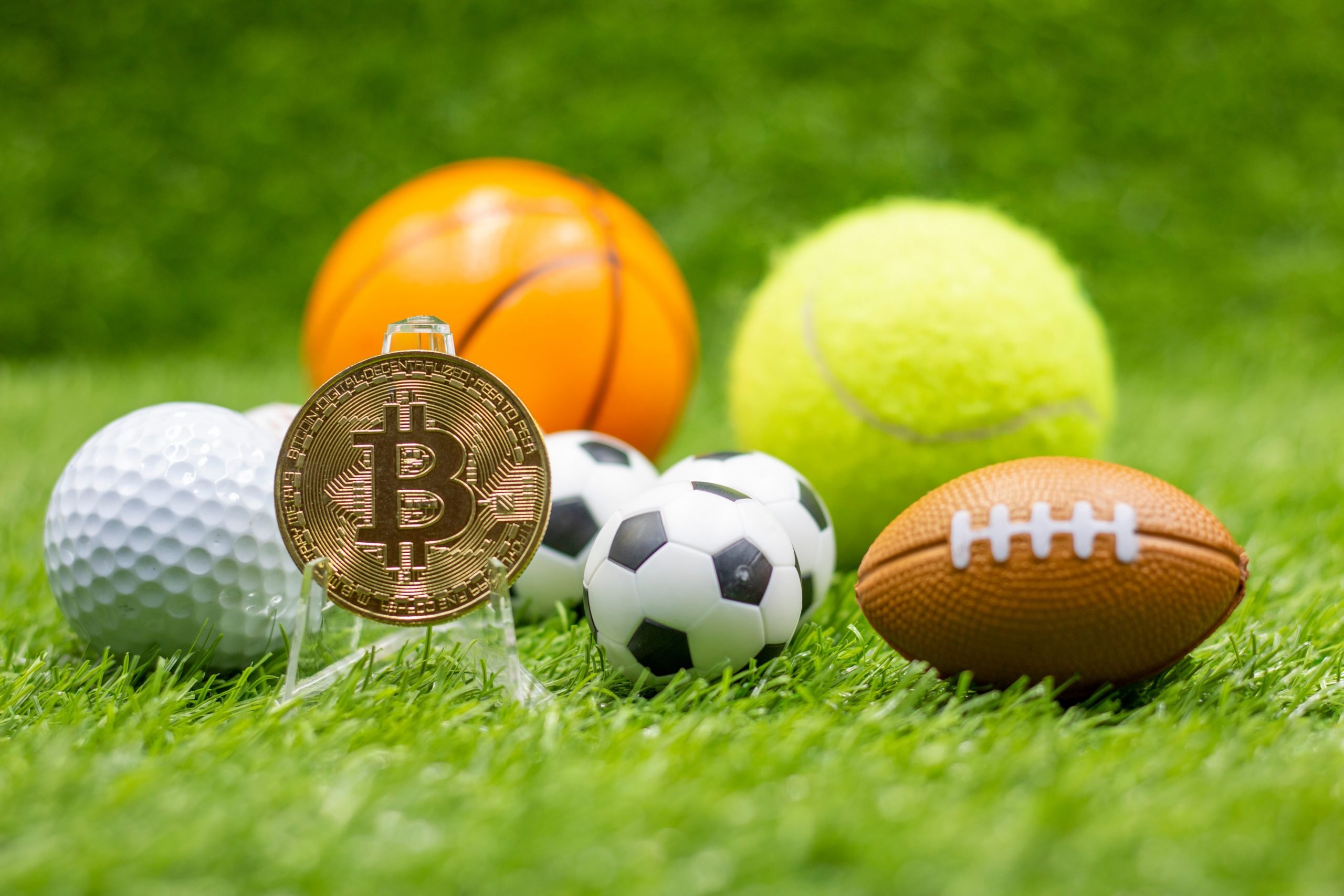 Bitcoin with soccer ball are on green grass for betting concept