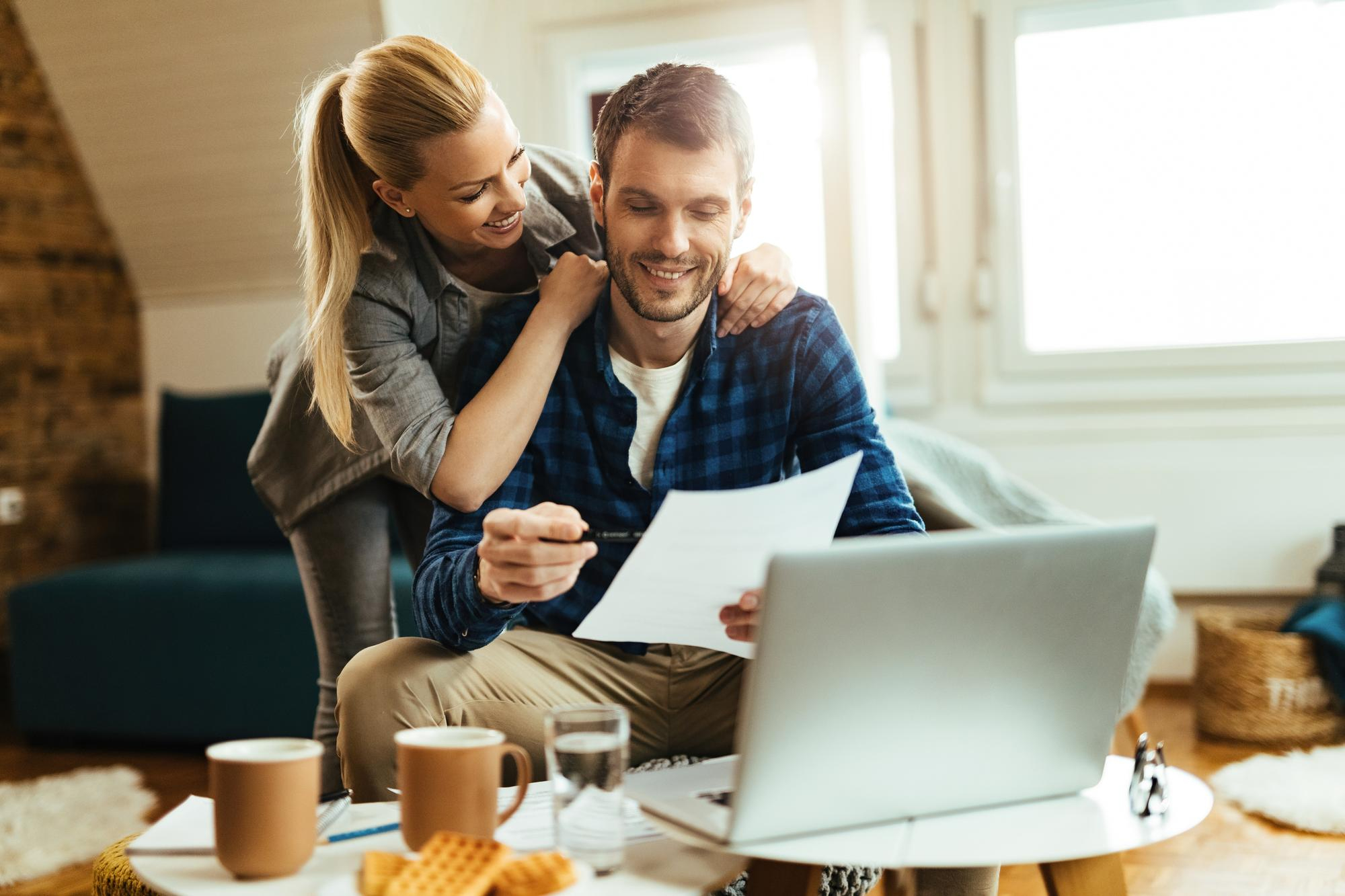 happy-couple-analyzing-their-home-budget-while-paying-bill-computer