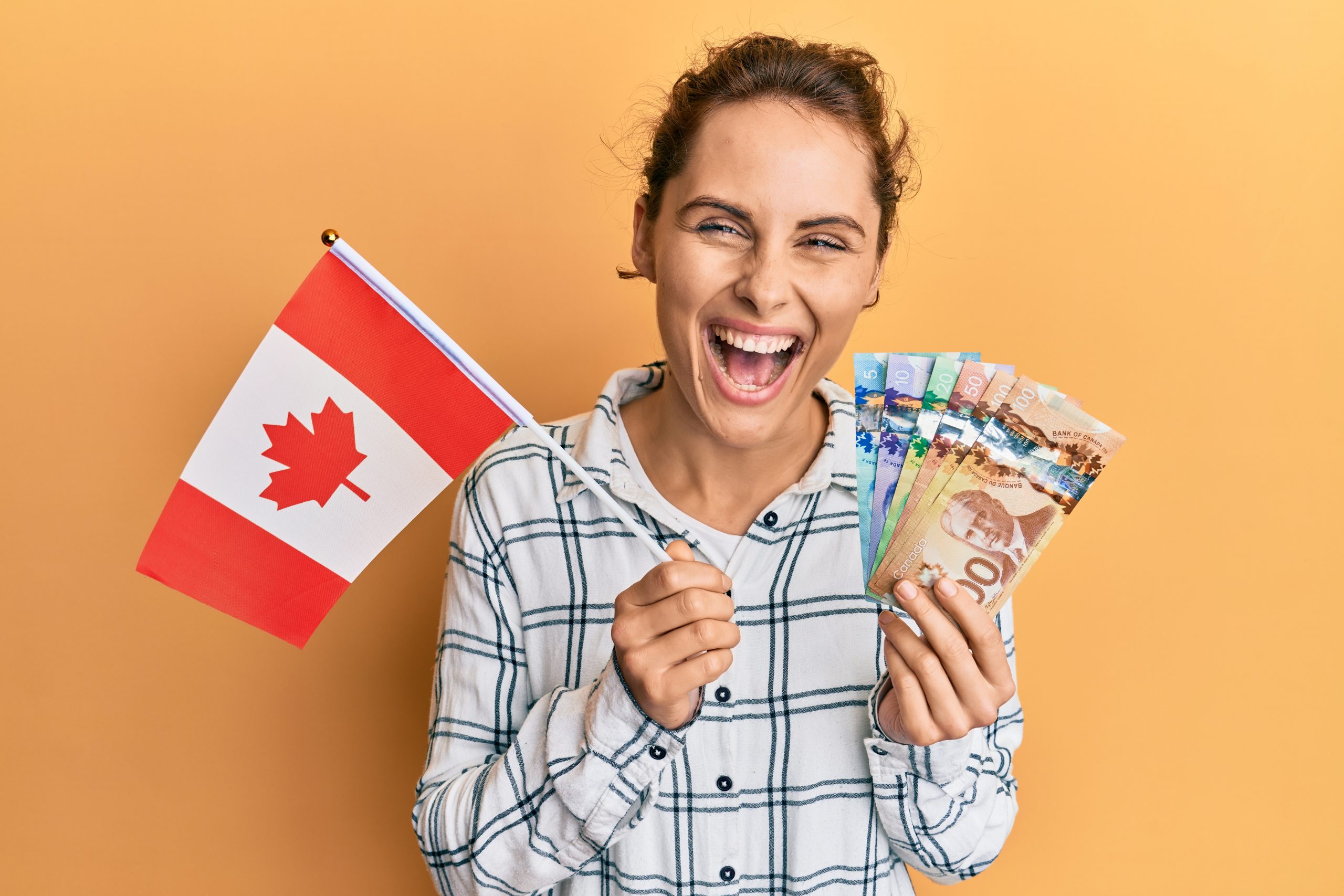 woman holding canada flag and dollars smiling