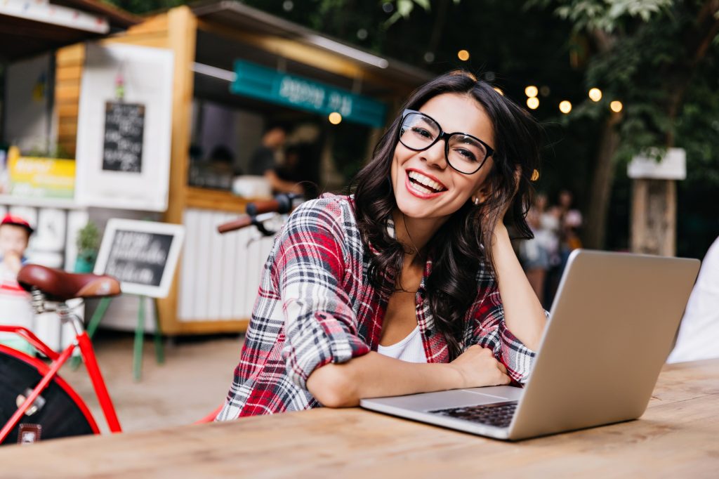 pretty woman smilling using notebook to invest