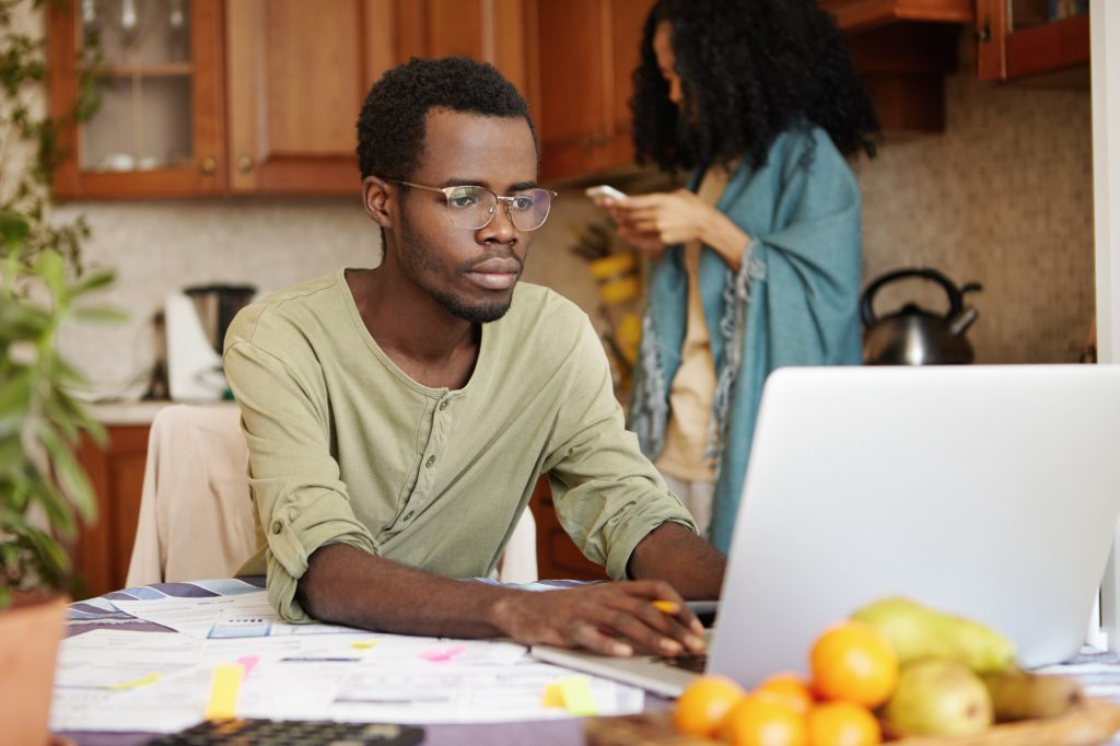 man paying bills at computer