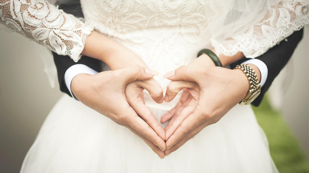 Wedding couple making a heart symbol
