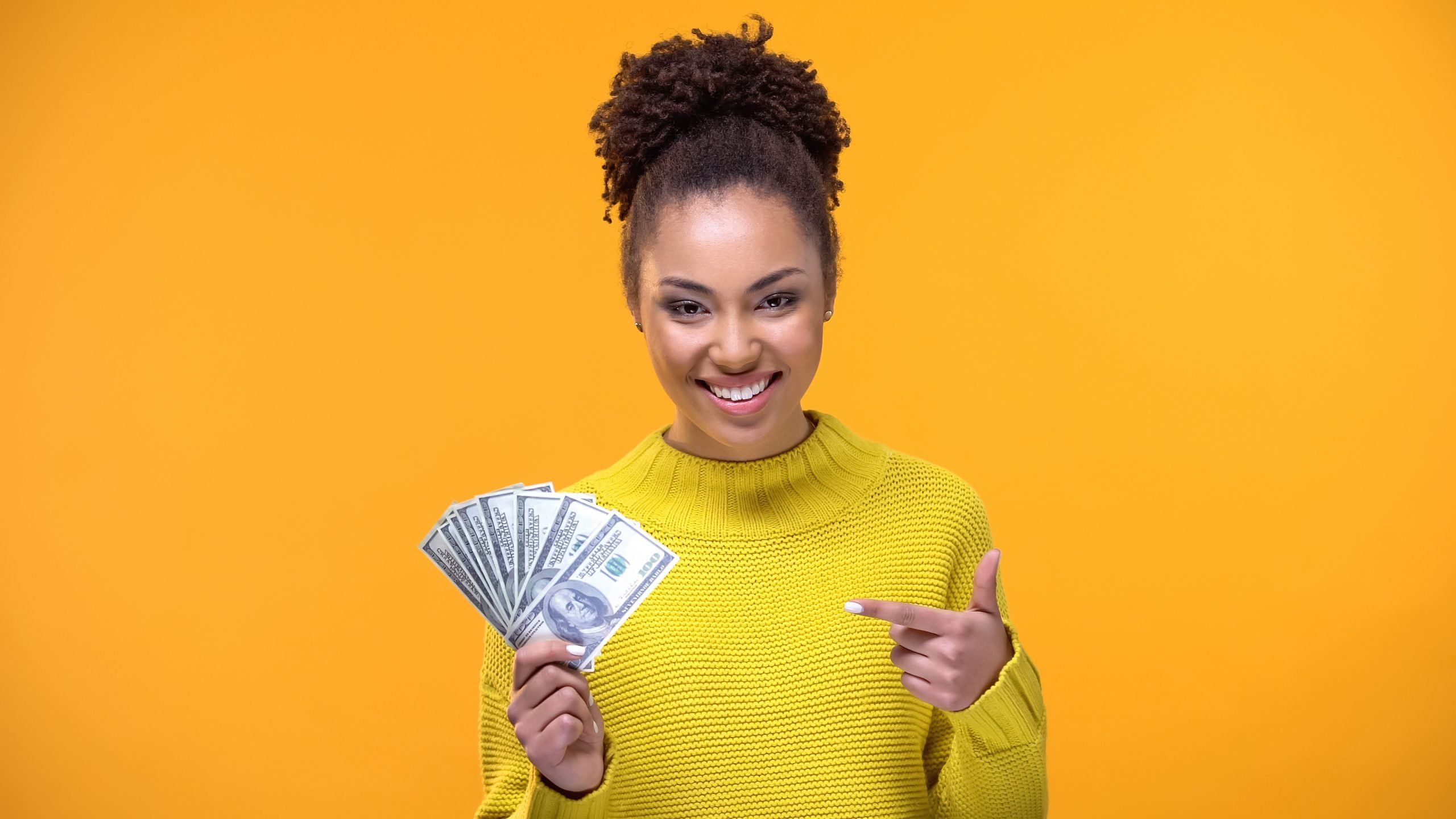 woman smiling and holding dollar bills