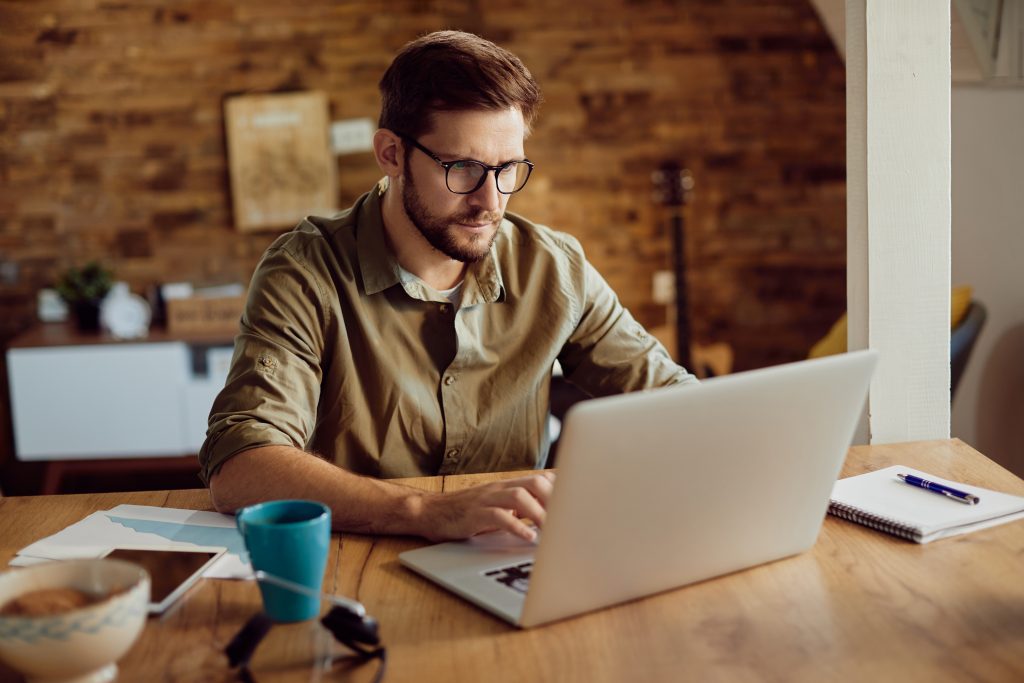 Male entrepreneur working on a computer at home.