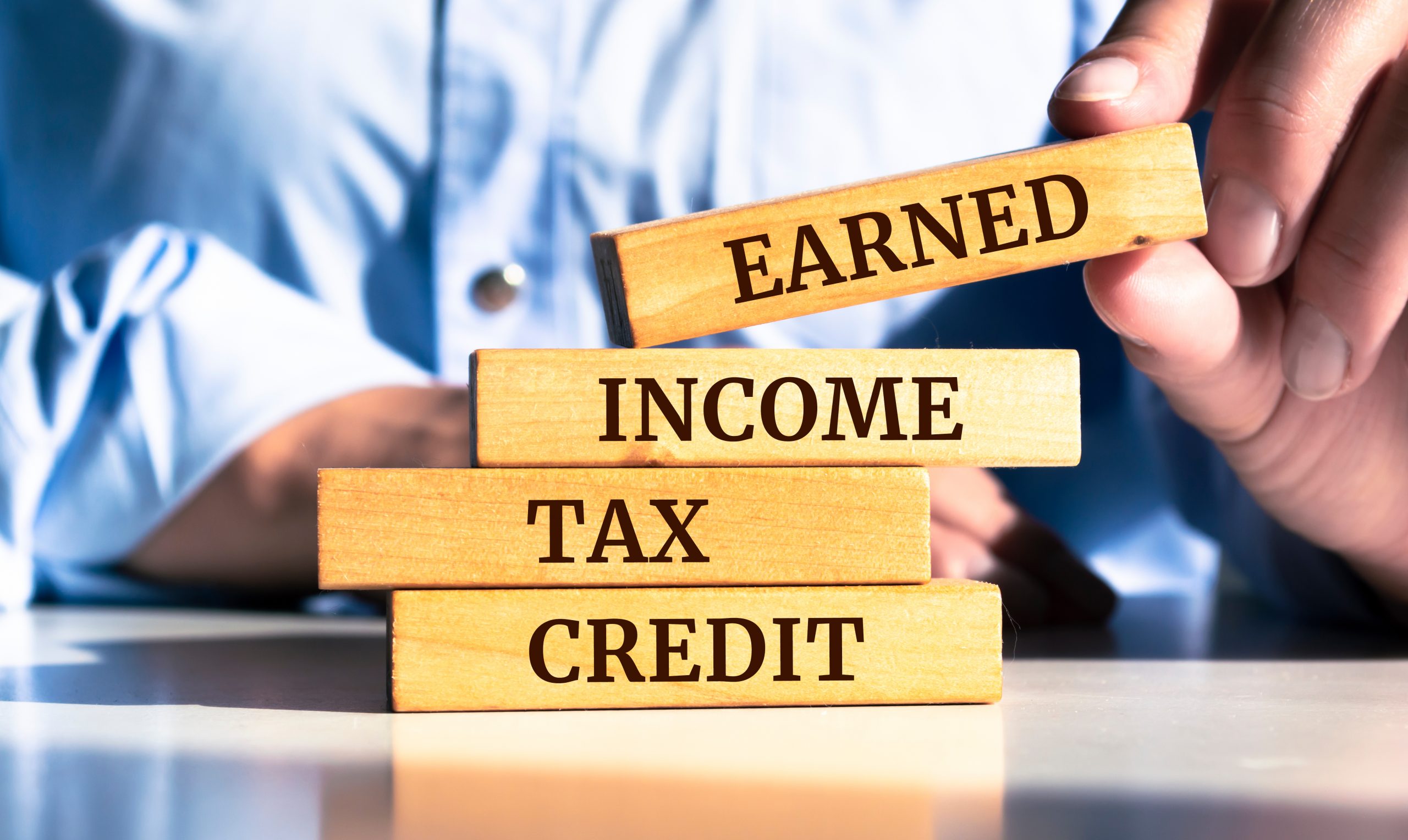 Wooden blocks with words 'EARNED INCOME TAX CREDIT'.