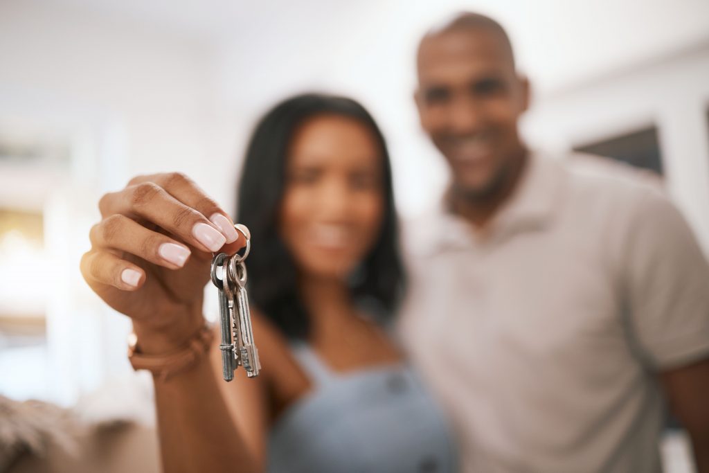 Happy couple, hands and keys for real estate purchase, property or homeowner with mortgage loan or finance.