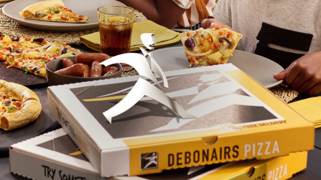 Debonairs Pizza boxes with the logo on top and people eating in the background
