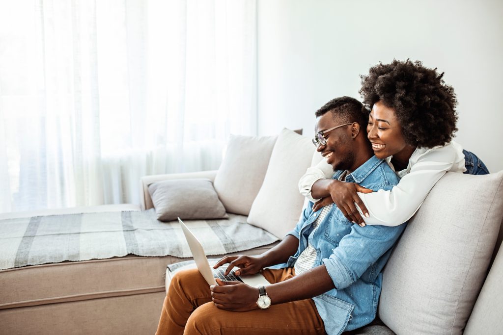 Happy young african couple with laptop computer. Happy black cou