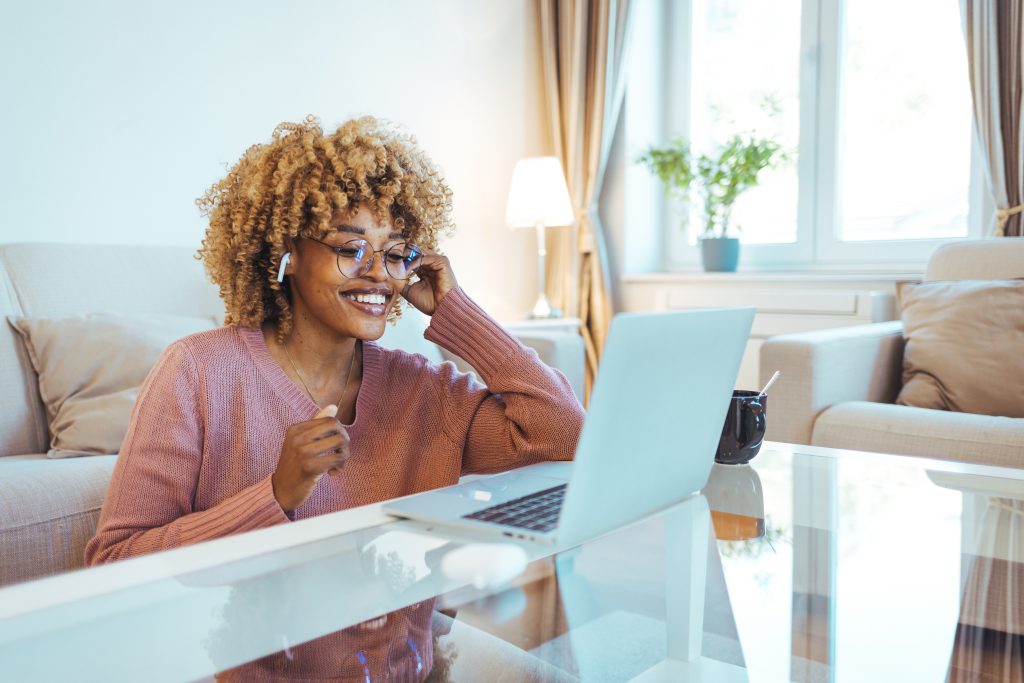 Smiling African American Woman Wearing Glasses and Wireless Earp