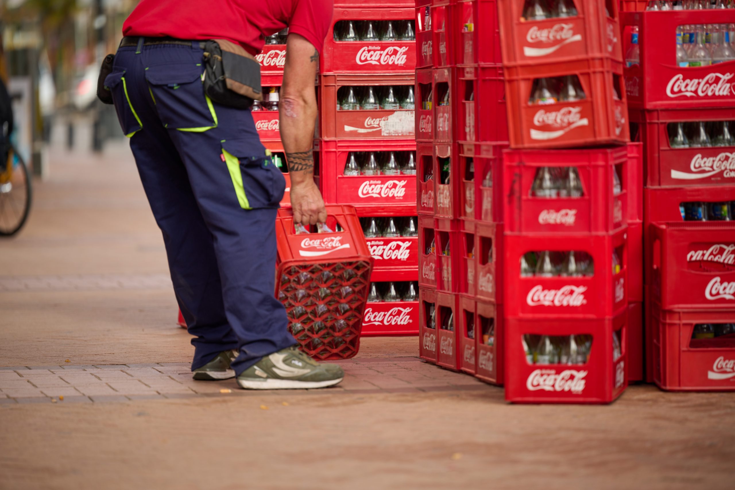 Man lifting a case of empty Coca Cola bottles