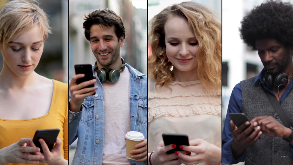 Pessoas sorrindo usando app de relacionamento em celular